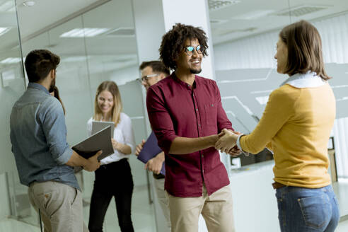 A group of creative young people standing in the modern startup office - INGF13234