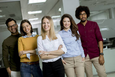 Portrait of group of young excited business people standing in office - INGF13236