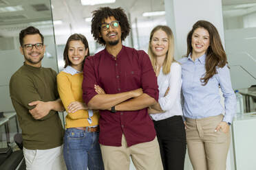 Portrait of group of young excited business people standing in office - INGF13237