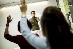 Group of young students rising hands to answer the question during the workshop training - INGF13255