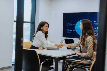 Young business women discussing in cubicle at the modern office - INGF13281