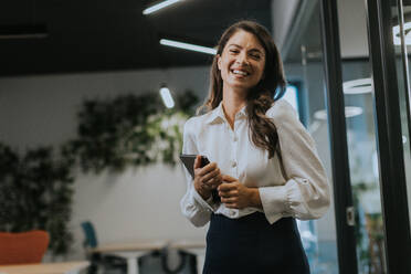 Young business woman with digital tablet standing in the modern office - INGF13289