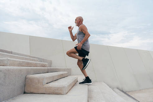 Retired active senior man moving up on steps - OIPF04051