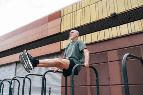 Active senior man exercising on parallel bars - OIPF04084