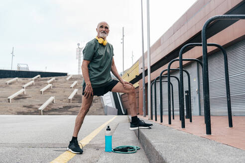 Retired senior man standing by parallel bars - OIPF04094