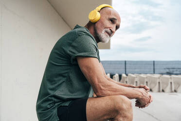 Senior man listening to music through wireless headphones - OIPF04120