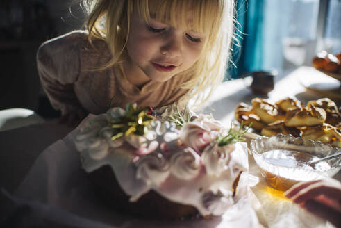 Neugieriges Mädchen betrachtet den Geburtstagskuchen auf dem Tisch - ASHF00083