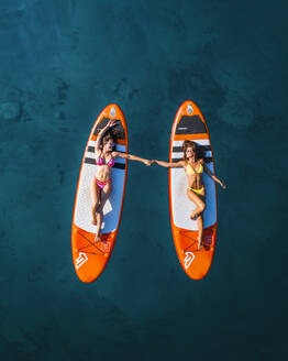 Aerial view of people surfing with turquoise waters and sunny weather, Primorje-Gorski Kotar, Croatia. - AAEF26245