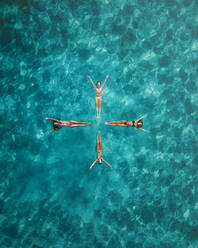 Aerial view of a sunny day gathering of joyful friends sunbathing on a tranquil and serene tropical island, Primorje-Gorski Kotar, Croatia. - AAEF26260