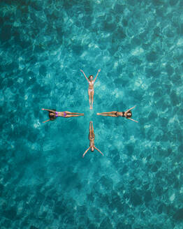 Aerial view of a sunny day gathering of joyful friends sunbathing on a tranquil and serene tropical island, Primorje-Gorski Kotar, Croatia. - AAEF26260