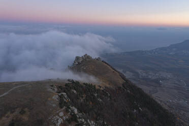 Aerial view of a mountain landscape with forest trees and low clouds at sunset in Crimea Region, Autonomous Republic of Crimea, Ukraine. - AAEF26414