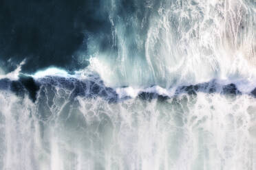 Luftaufnahme einer sich brechenden blauen Meereswelle mit weißem Schaum und einem blauen Bewegungseffekt, Kapstadt, Westkap, Südafrika. - AAEF26496