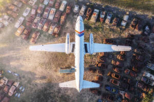 Luftaufnahme eines alten Flugzeugs, das auf einem Hof mit Oldtimerwracks geparkt ist, Kapstadt, Westkap, Südafrika. - AAEF26497