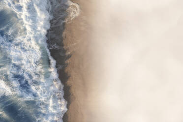 Aerial view of large waves crashing onto a pristine white sandy beach shore, Cape Town, Western Cape, South Africa. - AAEF26514