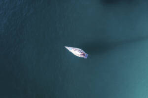 Aerial view of a small yacht anchored in a coastal bay in blue water, Cape Town, Western Cape, South Africa. - AAEF26519