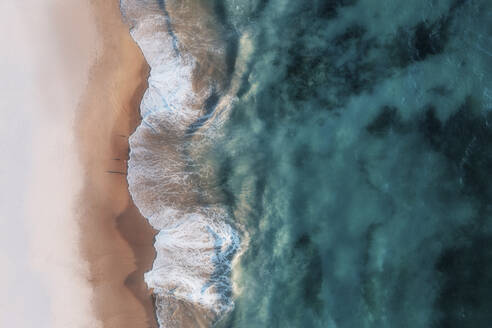 Luftaufnahme eines weißen Sandstrandes mit weißen Wellen, die ans Ufer rollen, und kristallklarem, blauem Wasser, Port Noarlunga, South Australia, Australien. - AAEF26546