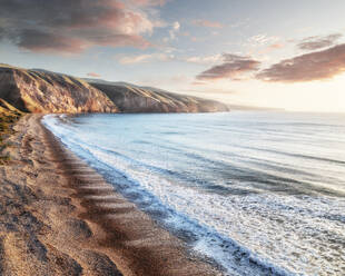 Luftaufnahme der Küste der Fleurieu Peninsula Sellicks Beach mit einer Person in einer orangefarbenen Jacke, die bei Sonnenuntergang am Strand steht, Fleurieu Peninsula, South Australia, Australien. - AAEF26555