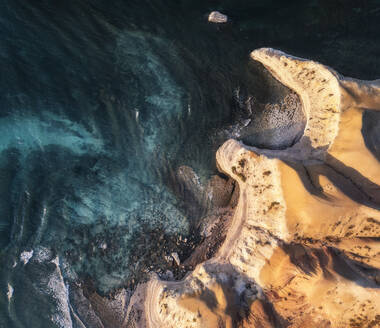 Luftaufnahme von Kalksteinklippen mit Sonnenuntergang und blauem Küstenwasser von oben mit einem kleinen Felsen in der Nähe der Spitze der Klippen, Port Willunga, Südaustralien, Australien. - AAEF26561