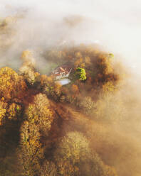 Aerial shot of a private house in Ascain at sunrise with mist, French Basque Country, Pyrénées-Atlantiques, Nouvelle-Aquitaine, France. - AAEF26756
