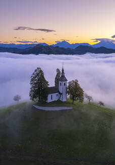 Luftaufnahme der wunderschönen Bergkirche Sveti Tomaz (St. Thomas) in Skofja loka, Slowenien, per Drohne. - AAEF26808