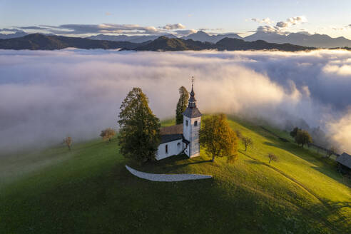 Luftaufnahme der wunderschönen Bergkirche Sveti Tomaz (St. Thomas) in Skofja loka, Slowenien, per Drohne. - AAEF26809