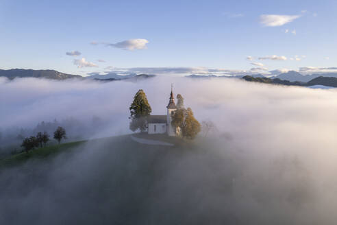 Luftaufnahme der wunderschönen Bergkirche Sveti Tomaz (St. Thomas) in Skofja loka, Slowenien, per Drohne. - AAEF26810