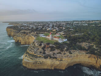 Aerial view of the beautiful rocky shoreline of Algarve, Farol de Alfanzina, Portugal. - AAEF26851