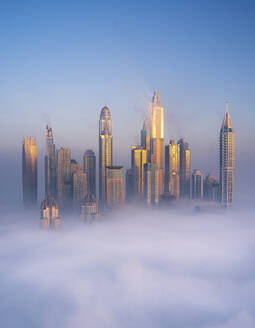 Aerial view of Dubai Marina with Cayan Tower and foggy skyline, Dubai, United Arab Emirates. - AAEF27024