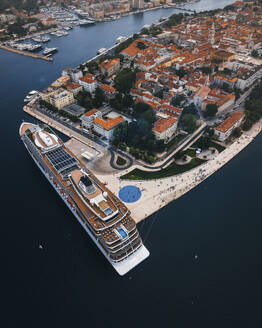 Aerial view of a cruise ship docked along Zadar coastline and marina with historic rooftops, Croatia. - AAEF27051