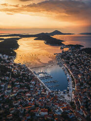 Aerial view of tranquil seaside town with orange sunset over the Mediterranean, Mali Losinj, Primorje-Gorski Kotar, Croatia. - AAEF27079