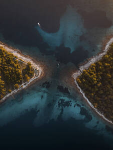 Aerial view of a tranquil seaside with boats and reflections, Croatia. - AAEF27083
