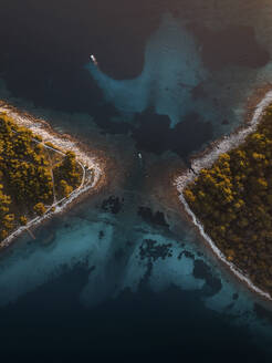 Aerial view of a tranquil seaside with boats and reflections, Croatia. - AAEF27083