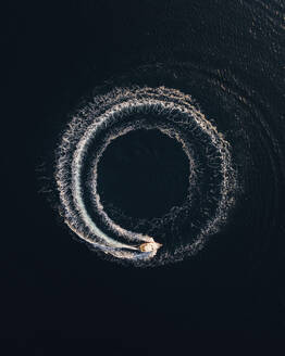 Aerial view of elegant motorboat circling in deep blue waters, Primorje-Gorski Kotar, Croatia. - AAEF27108