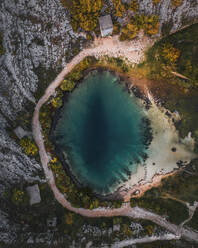 Aerial view of Vrelo Cetine, a serene and tranquil lake surrounded by green forests and autumn leaves, in Sibenik-Knin, Croatia. - AAEF27115