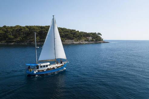 Aerial view of the Adriatic coast and sailboat in sunny summer day, Brac Island, Croatia. - AAEF27142