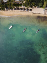 Aerial view of fishing boats on Pointe aux Canonniers coastline and clear Indian Ocean coastal reef, Grand Baie, Mauritius. - AAEF27171