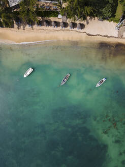 Aerial view of fishing boats on Pointe aux Canonniers coastline and clear Indian Ocean coastal reef, Grand Baie, Mauritius. - AAEF27171