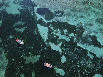 Aerial view of small fishing boat on crystal clear blue ocean, Pointe aux Canonniers, Grand Baie, Mauritius. - AAEF27177