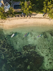 Aerial view of fishing boats on Pointe aux Canonniers and long shadows of people on beach, Grand Baie, Mauritius. - AAEF27192