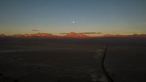 Aerial drone view of Volcano Licancabur with the moon in the sunset, San Pedro De Atacama, Chile. - AAEF27223