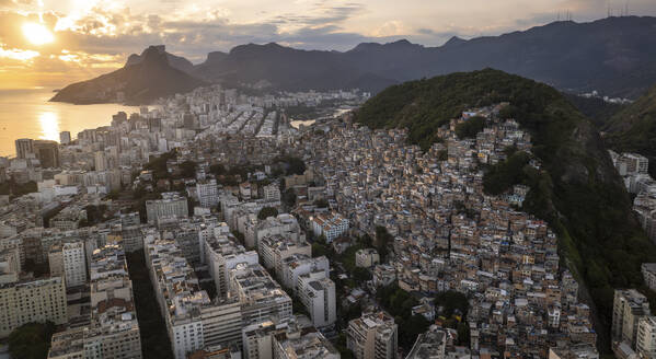 Aerial drone view of Favela Of Cantagalo with the city of Rio De Janeiro in the background in the sunset, Rio de Janeiro, Brazil. - AAEF27225