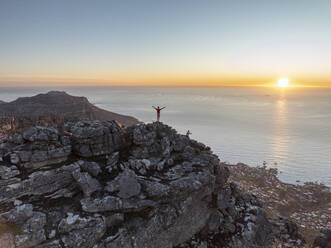 Luftaufnahme einer Person auf dem Gipfel des Tafelbergs bei Sonnenuntergang, Kapstadt, Westkap, Südafrika. - AAEF27310