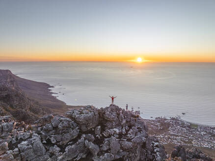 Luftaufnahme einer Person auf dem Gipfel des Tafelbergs bei Sonnenuntergang, Kapstadt, Westkap, Südafrika. - AAEF27312