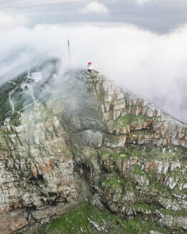 Luftaufnahme des alten Cape Point-Leuchtturms im Cape Point Nature Reserve Park mit tief hängenden Wolken auf dem Bergkamm, Kapstadt, Westkap, Südafrika. - AAEF27314