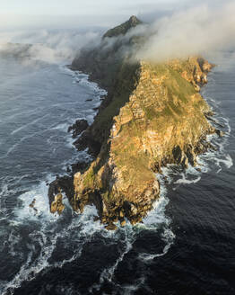 Luftaufnahme des alten Cape Point-Leuchtturms im Cape Point Nature Reserve Park mit tief hängenden Wolken auf dem Bergkamm, Kap der Guten Hoffnung, Kapstadt, Westkap, Südafrika. - AAEF27319