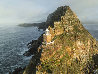 Luftaufnahme des alten Cape Point-Leuchtturms im Cape Point Nature Reserve Park mit tief hängenden Wolken auf dem Bergkamm, Kap der Guten Hoffnung, Kapstadt, Westkap, Südafrika. - AAEF27320