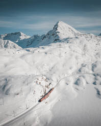Aerial Drone view of the Bernina Express Train traversing the Berninapass in Switzerland. - AAEF27379