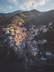 Luftaufnahme einer Drohne von Riomaggiore, Cinque Terre in Italien bei Sonnenaufgang. - AAEF27403