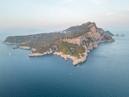 Luftaufnahme der Insel Capri bei Sonnenuntergang, Blick auf die Faraglioni-Felsformation entlang der Küstenlinie, Capri, Neapel, Kampanien, Italien. - AAEF27410