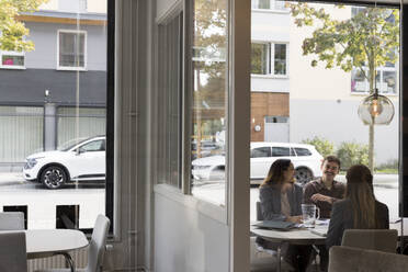 Happy customers discussing with female real estate agent at office - MASF43555